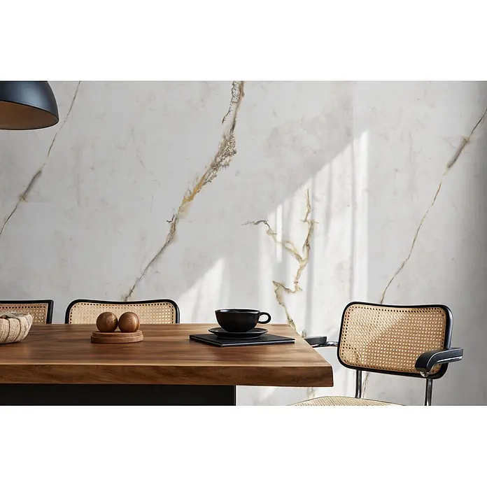 Feinsteinzeug in Gold extra Calacatta-Marmoroptik 60x120 - Ital. Fliesen -  - Schwarzer Stuhl mit Geflechtlehne und -sitz, an einem Esstisch aus Holz platziert.