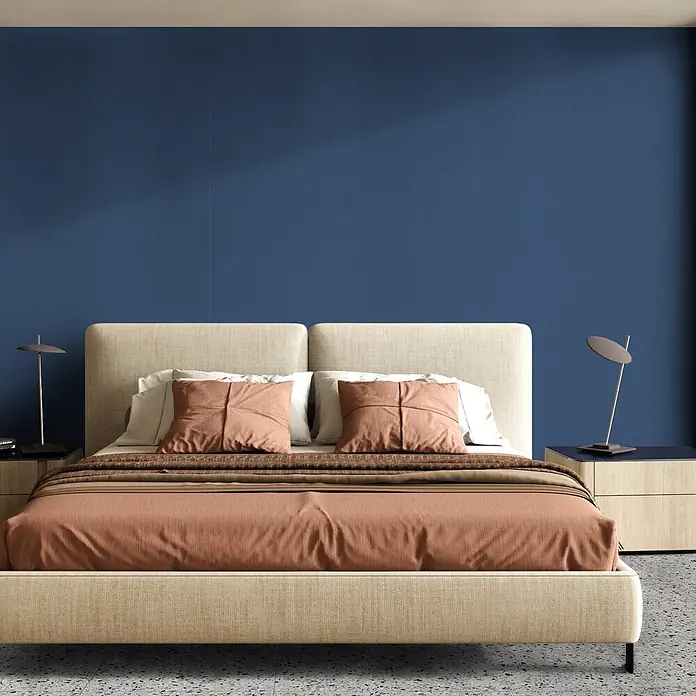 Feinsteinzeug in farbiger dunkelblauer Betonoptik 60x60 - Ital. Fliesen -  - Beiges Polsterbett mit Terrakotta-Bettwäsche in modernem Schlafzimmer.
