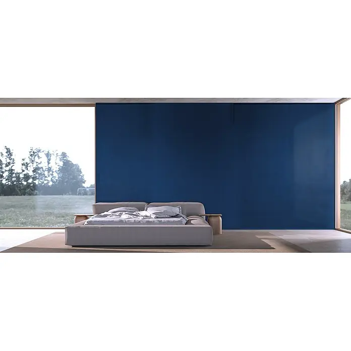 Feinsteinzeug in farbiger dunkelblauer Betonoptik 60x60 - Ital. Fliesen -  - Ein niedriges, gepolstertes hellgraues Bett mit weißer Bettwäsche in einem modernen Schlafzimmer mit großem Fenster und blauer Akzentwand.