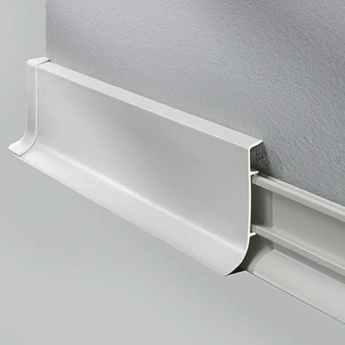 LOGOCLIC Sockelleiste KSL - 250 cm x 18,5 mm x 60 mm, Hellgrau - Detailaufnahme einer weißen, modernen Fußleiste, die an einer grauen Wand befestigt ist und ein sauberes, minimalistisches Design aufweist.