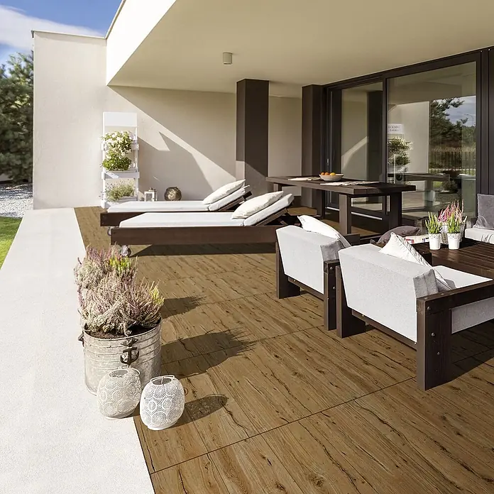 Feinsteinzeug in antiker Nussbaumholzoptik 30x120, rutschhemmend -  - Warme, braune Fliesen in Holzoptik bedecken eine geräumige moderne Terrasse mit Sitzgelegenheiten.