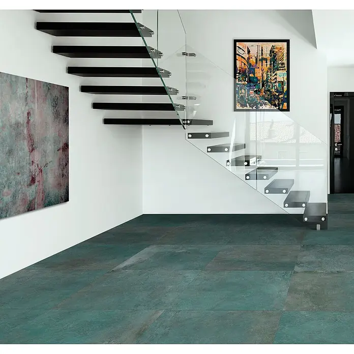 Feinsteinzeug in metallischer grüner Betonoptik 60x120 - Ital. Fliesen -  - Türkisfarbene, großformatige Bodenfliesen mit rustikaler Textur, verlegt in einem modernen Interieur mit einer freitragenden Treppe.