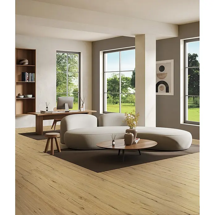 Feinsteinzeug in antiker honig Holzoptik 20x120 - Italienische Fliesen -  - Ein modernes Home-Office und Wohnbereich mit hellbeigem, geschwungenem Sofa, Holzschreibtisch und hellem Holzboden.