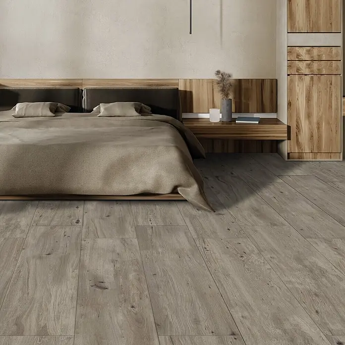 Feinsteinzeug in roher matter grauer Holzoptik 30x120 - Ital. Fliesen -  - Gebraucht aussehender, hellbrauner Holzboden mit natürlicher Textur, elegant in einem modernen Schlafzimmer verlegt.