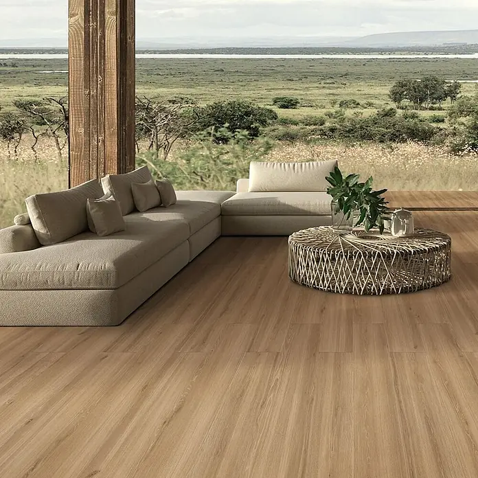 Feinsteinzeug in honigfarbener Holzoptik 20x120, rutschhemmend -  - Große hellbeige Sofalandschaft mit rundem Kaffeetisch aus Geflecht in modernem Wohnzimmer mit Naturblick.