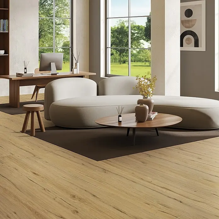 Feinsteinzeug in antiker honigfarbener matter Holzoptik 30x120 -  - Heller Holzboden mit natürlicher Maserung in einem modernen Wohnbereich mit Sofa, Schreibtisch und Couchtisch.