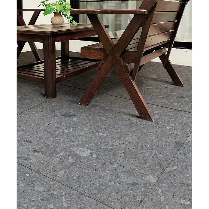 Feinsteinzeug in grauer Steinoptik 60x120, 20 mm, rutschhemmend -  - Dunkelgraue Outdoor-Bodenfliesen in Terrazzo-Optik auf einer Terrasse unter Holzmöbeln.