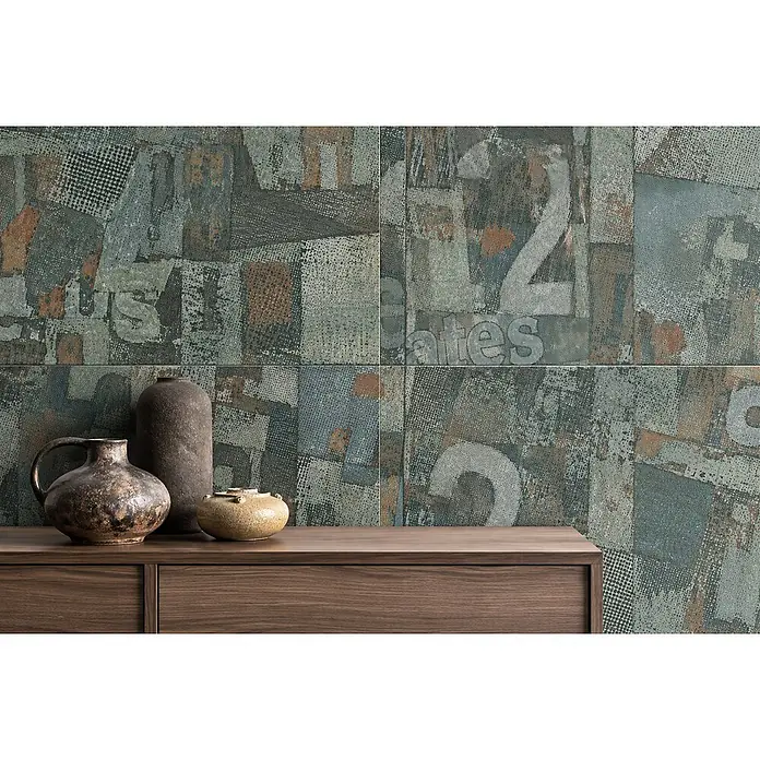 Dekorierte industrielle Feinsteinzeug Wandfliese in Grün - Ital. Fliesen -  - Industrielle Wandfliesen mit Used-Optik, Zahlen und Text in Blaugrün- und Rosttönen, hinter einem Holzschrank.