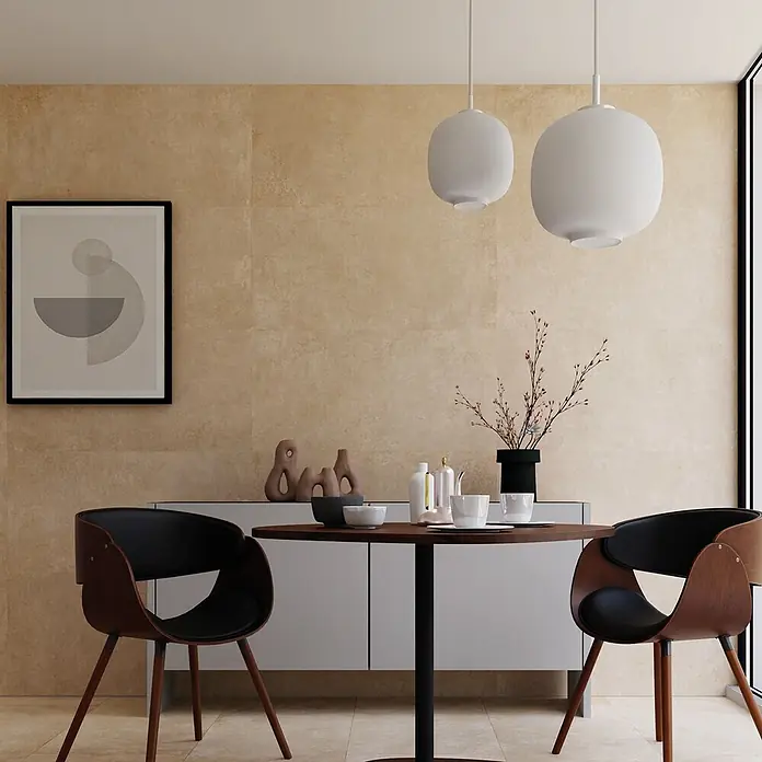 Feinsteinzeug in beiger Betonoptik 120x120 - Italienische Fliesen -  - Moderner Essbereich mit einem runden dunklen Holztisch, zwei Holzstühlen mit schwarzen Sitzen und zwei weißen Pendelleuchten.
