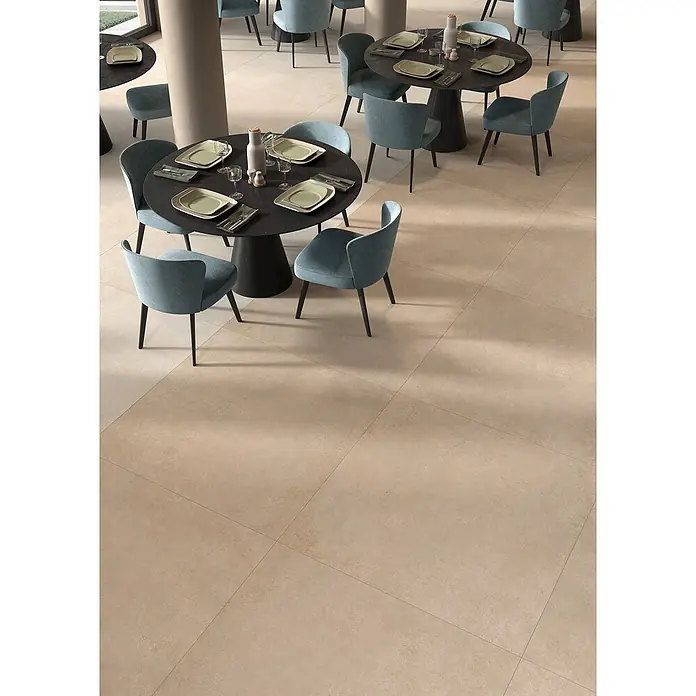 Feinsteinzeug in beiger Betonoptik 120x120 - Italienische Fliesen -  - Großformatige beige Bodenfliesen mit matter Oberfläche in einem Restaurant, die eine neutrale, geräumige Grundlage bieten.