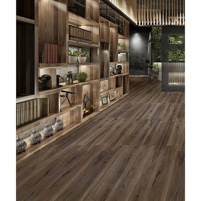 Feinsteinzeug in dunkelbrauner Holzoptik 20x120 - Italienische Fliesen -  - Dunkelbrauner Holzboden erstreckt sich durch einen modernen Raum mit eingebauten Holzregalen und Umgebungslicht, der sein warmes, strukturiertes Aussehen hervorhebt.