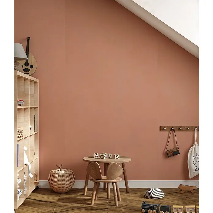 Feinsteinzeug in farbiger rosafarbener Betonoptik 60x120 - Ital. Fliesen -  - Texturierte terrakottafarbene Wand in einem Kinderzimmer, die einen warmen und einladenden Hintergrund schafft.