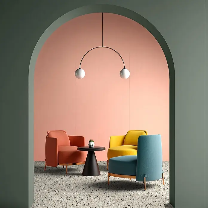 Feinsteinzeug in farbiger rosafarbener Betonoptik 60x120 - Ital. Fliesen -  - Moderne Loungesessel in Koralle, Gelb und Blau mit schwarzem Beistelltisch und minimalistischer Pendelleuchte in modernem Bogenraum.