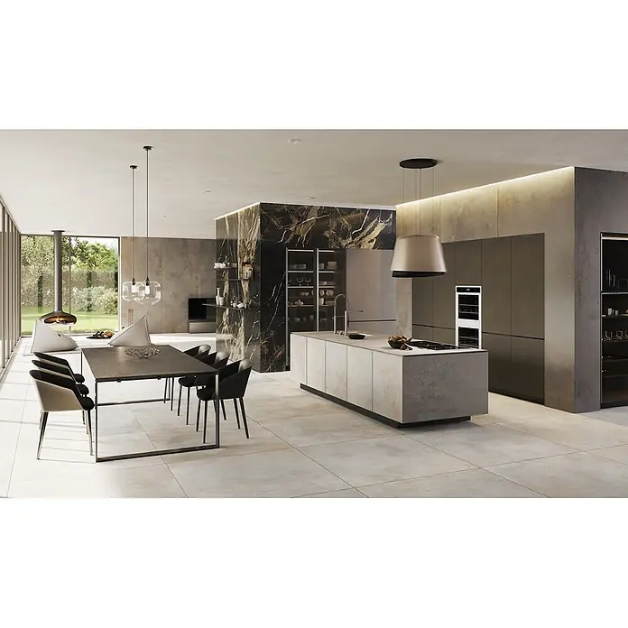 Feinsteinzeug in metallischer hellgrauer Betonoptik 60x120 - Ital. Fliesen -  - Elegante offene Küche und Essbereich mit heller Steinkücheninsel, dunklem Esstisch und markanter schwarzer Marmorwand.
