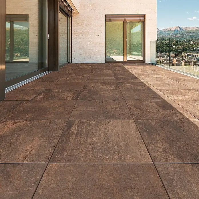 Feinsteinzeug in Metalloptik 60x60, 20 mm, rutschhemmend - Ital. Fliesen -  - Rostfarbene Outdoor-Fliesen pflastern eine moderne Terrasse mit Aussicht.
