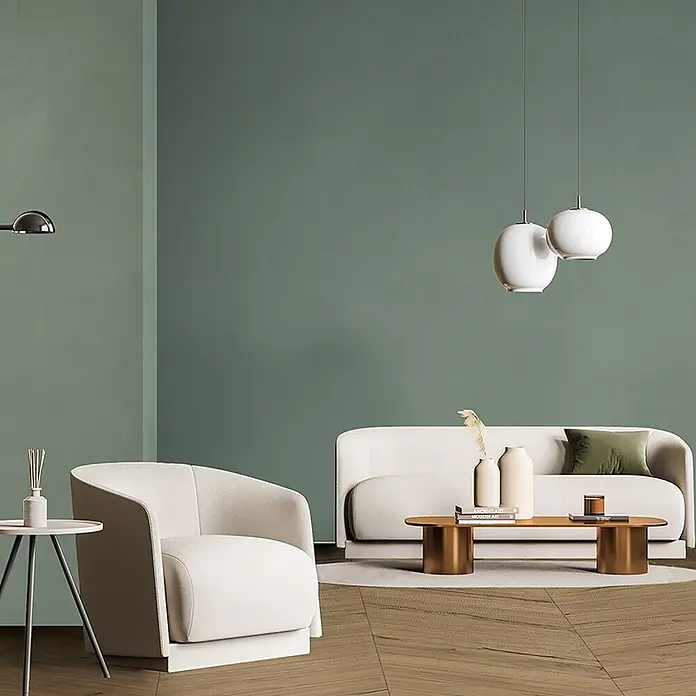 Feinsteinzeug in farbiger salbeigrüner Betonoptik 60x60 - Ital. Fliesen -  - Ein modernes Wohnzimmer mit einem cremefarbenen Sofa und Sessel, einem Holztisch und kugelförmigen Pendelleuchten.