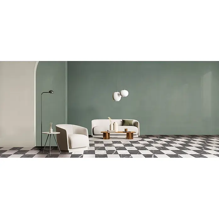 Feinsteinzeug in farbiger salbeigrüner Betonoptik 60x60 - Ital. Fliesen -  - Modernes Wohnzimmer mit hellem Sessel und Sofa, bronzefarbenem Couchtisch und weißem Beistelltisch. Weiße Pendelleuchten darüber.