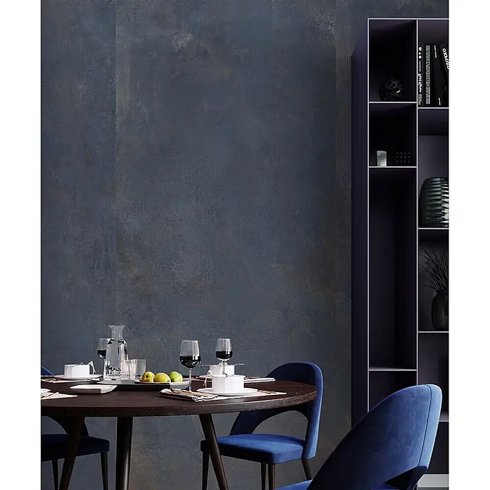 Feinsteinzeug in metallischer blauer Betonoptik 60x60 - Ital. Fliesen -  - Dunkelblaue strukturierte Wandplatte in modernem Esszimmer, passend zu dunklen Möbeln und blauen Stühlen.