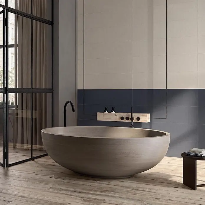 Feinsteinzeug in beiger Invecchiato Dielenoptik Holzoptik 20x120 -  - Große, hellbraune, schalenförmige Badewanne in einem modernen Badezimmer mit Holzboden und zweifarbiger Fliesenwand.