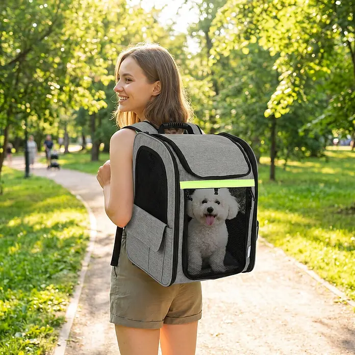 PawHut Katzentransporttasche Hellgrau 33,5L x 28B x 42H cm -  - Grauer Haustiertrage-Rucksack, getragen von einer Person, mit einem kleinen weißen Hund darin, beim Gehen in einem sonnigen Park.