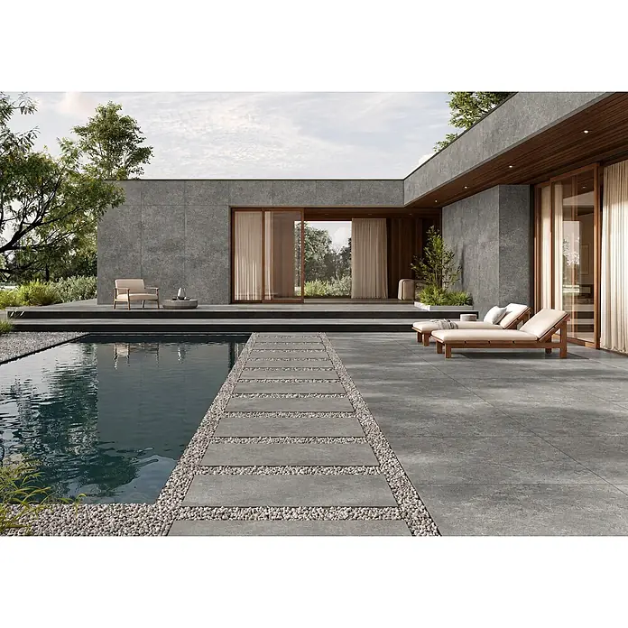 Feinsteinzeug Außen strukturierter grauer Betonoptik 60x120, R11 -  - Dunkelgraue, texturierte Outdoor-Feinsteinzeugfliesen auf Terrasse, Poolrand und moderner Hausfassade.