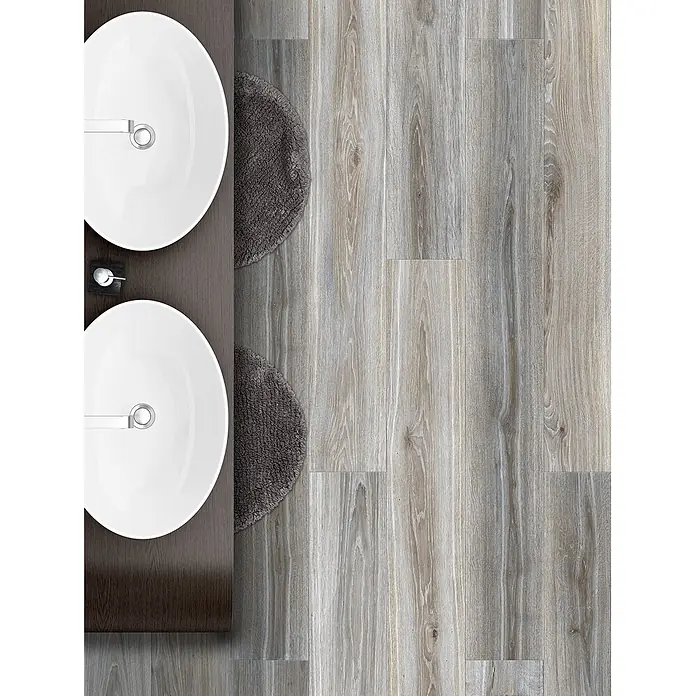 Feinsteinzeug in grauer Holzoptik 20x120 - Italienische Fliesen -  - Zwei weiße ovale Waschbecken mit Chromarmaturen in dunklem Holzwaschtisch, neben hellem Holzfußboden und grauen Teppichen.
