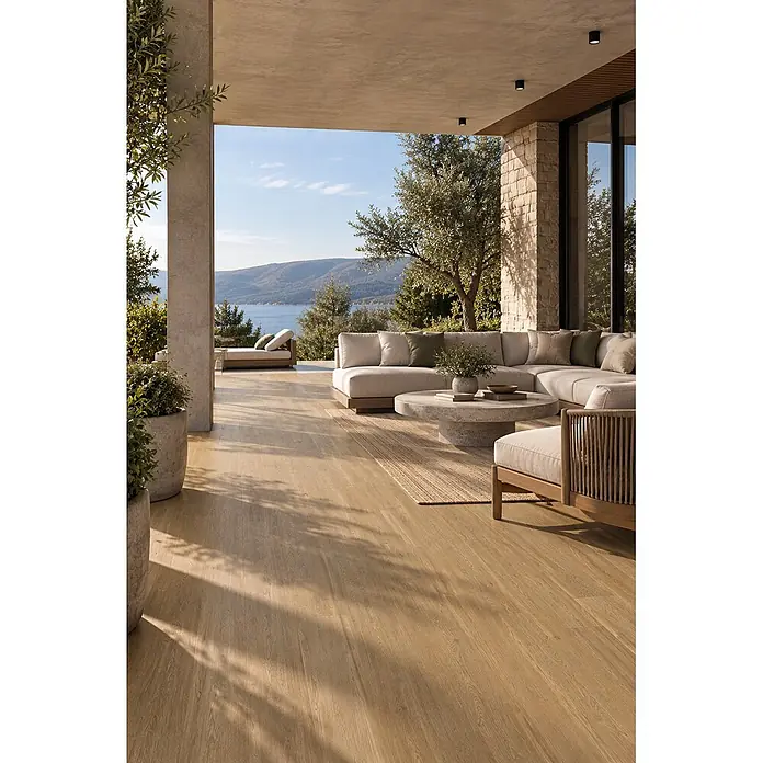 Feinsteinzeug in dunkelbrauner Holzoptik 20x120 - Italienische Fliesen -  - Heller Holzoptik-Dielenboden auf einer großzügigen Außenterrasse, mit modernen Loungemöbeln und Meerblick.