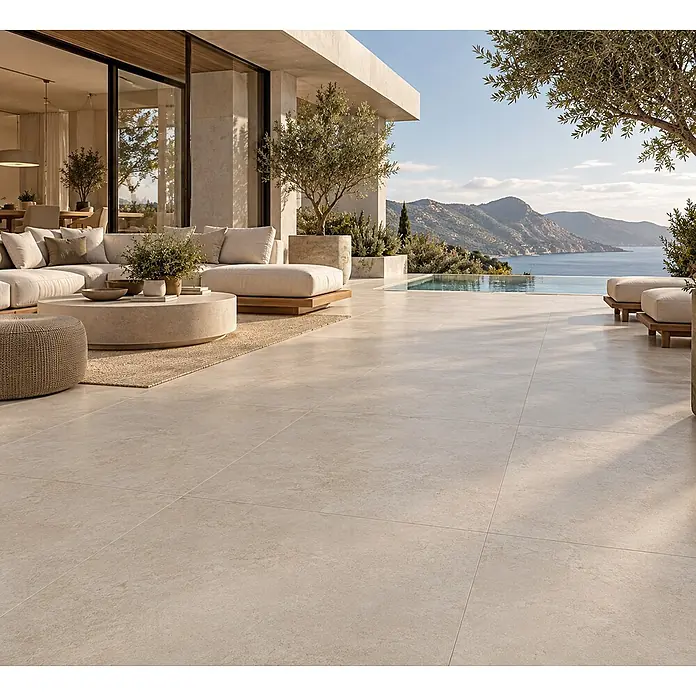 Feinsteinzeug in elfenbein natürlicher Steinoptik 120x120 - Ital. Fliesen -  - Helle, beige Outdoor-Bodenfliesen auf einer geräumigen modernen Terrasse mit Sitzbereich und Infinity-Pool mit Meerblick.