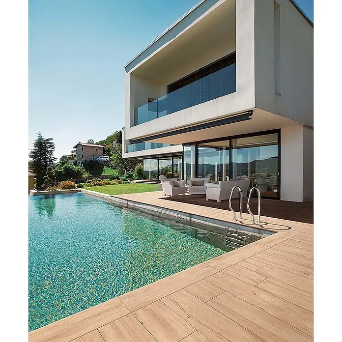 Feinsteinzeug in roher beiger Holzoptik 30x120, rutschhemmend -  - Holzoptik-Fliesen bilden eine stilvolle Poolterrasse neben einem modernen Haus.