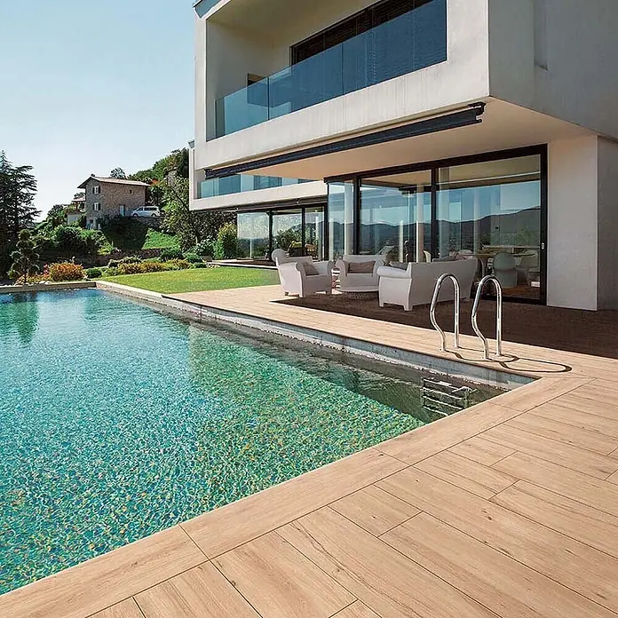 Feinsteinzeug in roher beiger Holzoptik 30x120, rutschhemmend -  - Helle Holzoptik-Planken bilden eine elegante Poolterrasse und einen Loungebereich eines modernen Hauses.