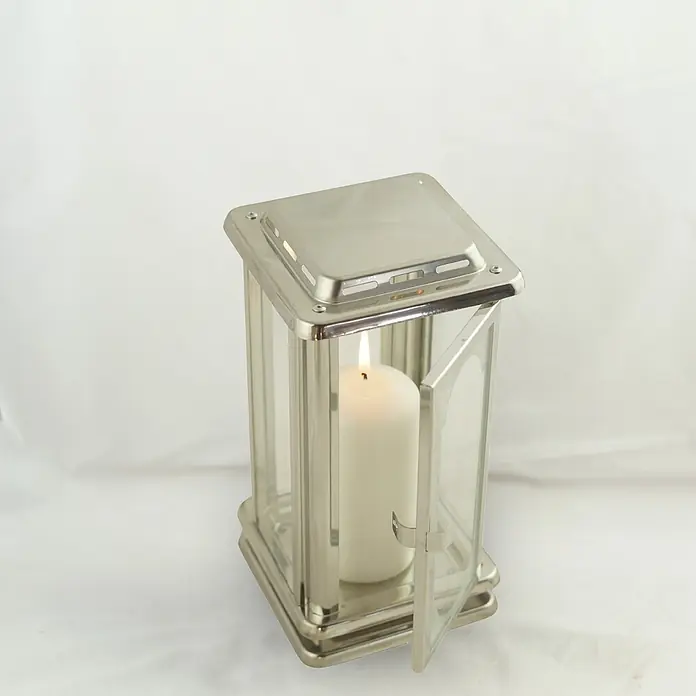 Grablaterne Royal, 12x12x23 cm, Edelstahl, Silber mit Bohrloch -  - Silberne Metalllaterne mit Glasscheiben und brennender weißer Kerze; eine Tür ist offen.