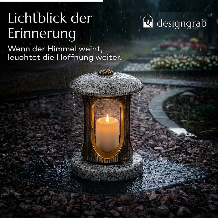 Runde Grablaterne Ø 15 cm, H 22 cm, Granit Orion, Gold-Messing -  - Grablampe aus Granit und Metall mit brennender Kerze, auf Kies auf einem Friedhof im Regen.