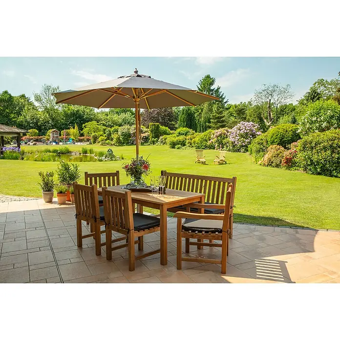 Teak Gartensessel ohne Armlehnen Massivholz wetterfest und pflegeleicht -  - Holz-Garten-Essgarnitur mit Tisch, Stühlen, Bank und Sonnenschirm auf einer Terrasse im Garten.