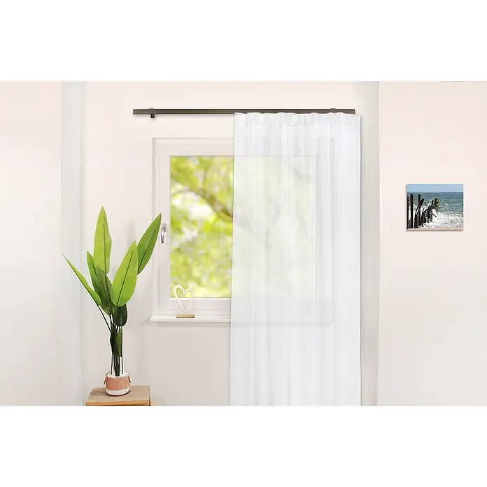 Gardinenschienen-Set Länge 210cm Loft 1-lauf Edelstahl-optik Aluminium -  - Ein weißer, transparenter Gardinenschal hängt an einer dunklen Stange und filtert sanft das Licht in einem modernen Raum mit Fenster.