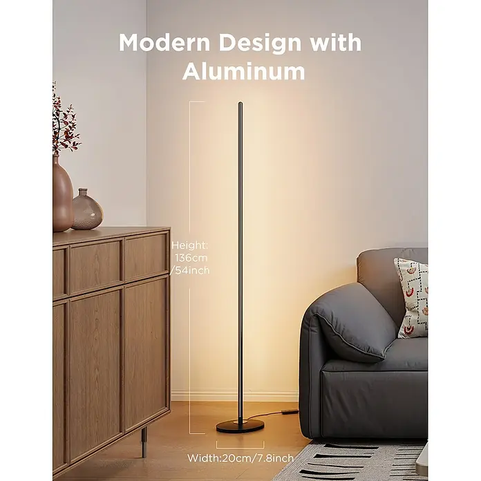 Govee LED-Stehleuchte Lamp Lite - 24 W, Höhe: 136,3 cm, Schwarz - Eine hohe, schlanke schwarze Aluminium-Stehleuchte, die warmes Licht abstrahlt, steht zwischen einem grauen Sofa und einem Holzschrank. 136cm H x 20cm B.