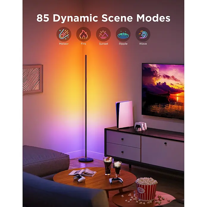 Govee LED-Stehleuchte Lamp Lite - 24 W, Höhe: 136,3 cm, Schwarz - Eine schlanke, schwarze Eckstehlampe beleuchtet eine Wohnzimmerecke mit lebendigen orange-violetten dynamischen Lichtern und zeigt 85 Szenenmodi.