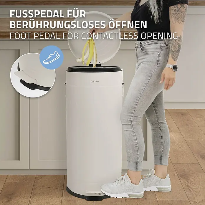 ML-Design Treteimer 30 l, Beige, Stahl -  - Weißer, zylindrischer Treteimer in Gebrauch, mit Fußpedal zum berührungslosen Öffnen. Eine Person entsorgt Bananenschalen.