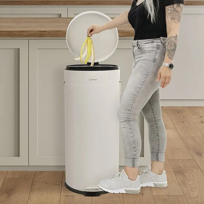 ML-Design Treteimer 30 l, Beige, Stahl -  - Weißer zylindrischer Treteimer mit schwarzem Deckel und Sockel, wird zum Entsorgen einer Bananenschale verwendet.