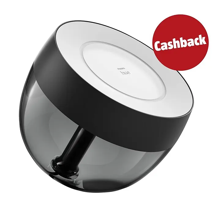 Philips Hue LED-Tischleuchte Iris - Schwarz/Transparent, Höhe: 19,4 cm - Eine geneigte Philips Hue Smart-Lampe mit transluzentem dunkelgrauem Unterteil, weißer Oberseite mit 'PHILIPS hue' Logo und rotem 'Cashback'-Aufkleber.