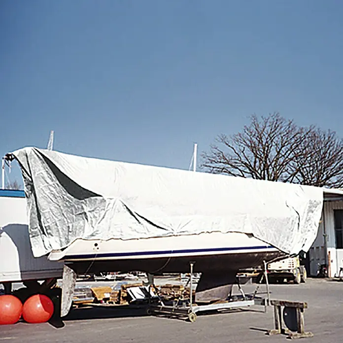 Talamex Abdeckplane - 4 x 5 m, Polyethylen, Weiß - Abgedecktes Segelboot auf einem Anhänger, bereit für den Transport oder die Lagerung im Freien, mit klarem blauem Himmel.