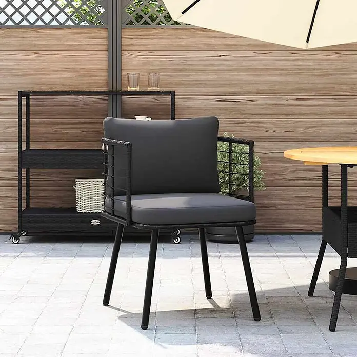 Furnicato Gartenstuhl PE-Rattan Schwarz mit Kissen -  - Dunkelgrauer Outdoor-Esszimmerstuhl mit schwarzem Metallrahmen und geflochtenen Akzenten, auf einer Terrasse.