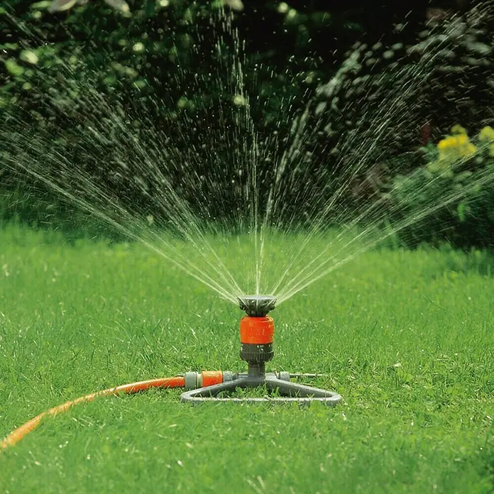 Gardena Comfort Kreisregner Vario - Drehstrahlturbine, Mit Schmutzsieb, Max. Regnerfläche: 225 m² - Rasensprenger bewässert den grünen Rasen mit einem feinen Sprühnebel. Das Gerät ist orange und grau.