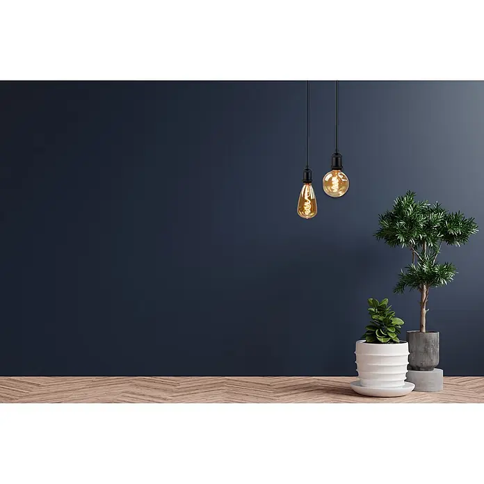 ENOVALITE LED-Leuchtmittel E27 4 W 2200 K Warmweiß Dimmbar -  - Ein modernes Zimmer mit dunkelblauer Wand, Fischgrätparkett, zwei bernsteinfarbenen Edison-Glühbirnen und zwei grünen Topfpflanzen.