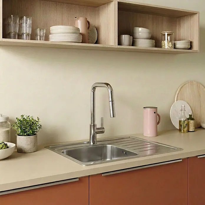 Schöner Wohnen Runa Küchenarmatur Ausziehbar mit Brause Chrom -  - Küchenspüle aus Edelstahl mit modernem Chromhahn in heller Beigearbeitsplatte, umgeben von Terrakotta-Schränken und offenen Holzregalen.