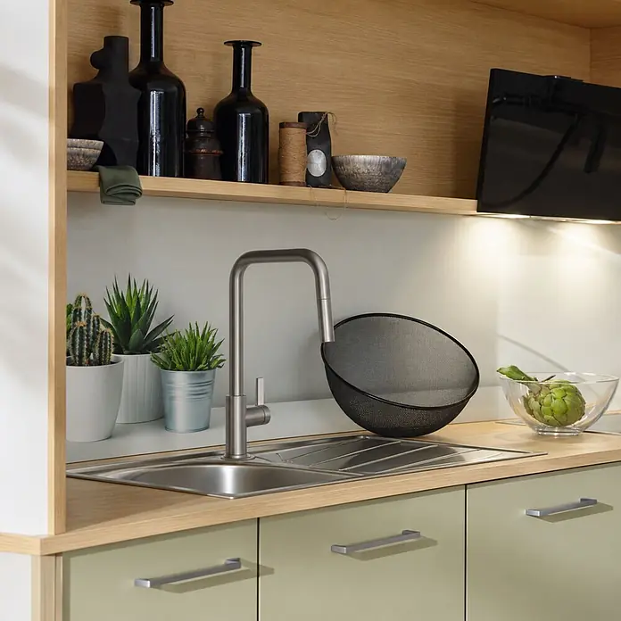 Schöner Wohnen Runa Küchenarmatur Ausziehbar mit Brause Edelstahl Optik -  - Edelstahlspüle und gebürsteter Metallwasserhahn in moderner Küche mit Holzregalen und hellgrünen Schränken.