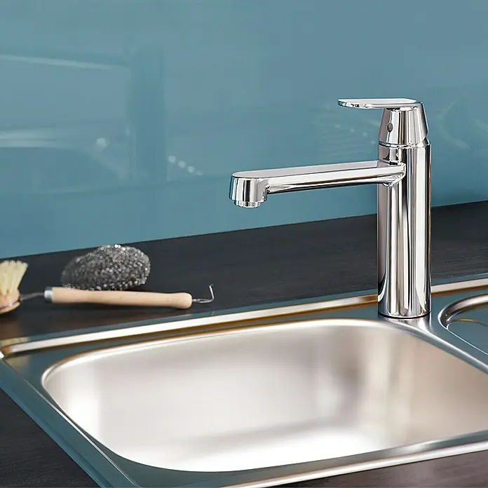 Grohe Eurosmart Cosmopolitan Spültischarmatur - L-Auslauf, Chrom, Glänzend, Schwenkbar - Glänzender Chrom-Wasserhahn über einer Edelstahlspüle. Ideal für moderne Küchen, bietet Stil und Funktionalität.