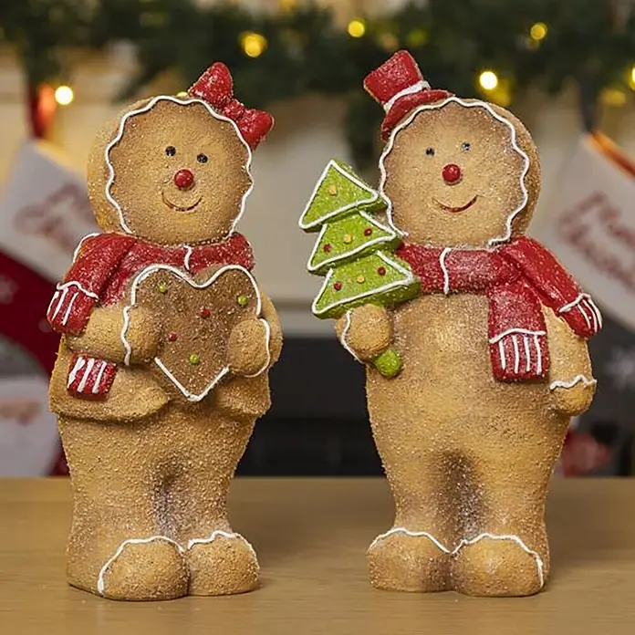Dekoartikel Lebkuchen - Mehrfarbig, Kunststein, Motiv: Lebkuchen - Zwei festliche Lebkuchen-Figuren, ein Mädchen mit Herz und ein Junge mit Weihnachtsbaum, dekoriert mit roten Schals und Zuckerguss, als Weihnachtsdeko.