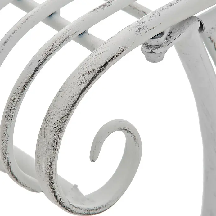 Furnicato Gartenbank Karma Jugendstil aus Eisen -  - Nahaufnahme eines patinierten, weißen Metallornaments mit sichtbaren Abnutzungsspuren und dunklen Akzenten, das dekorative Kurven und eine Schraubverbindung zeigt.