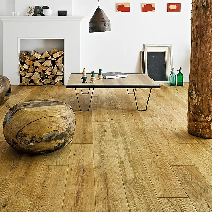 Parkett - Eiche natur geölt, Landhausdiele, 1.092 x 180 x 14 mm - Ein gemütliches Wohnzimmer mit einem hellen Holzboden, einem Holzhocker und einem Couchtisch mit Schachfiguren. Der Holzboden verleiht dem Raum Wärme.