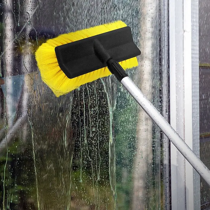 Autowaschbürste Schwarz - Gelb aus Aluminium -  - Gelbe Waschbürste mit schwarzem Kopf und silberner Teleskopstange reinigt ein nasses Fenster.